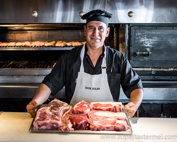 A chef presenting a tray of high-quality raw beef cuts.